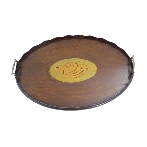 1262 - A Victorian mahogany tray of oval form with scalloped edge gallery, twin brass handles and inlaid sh... 