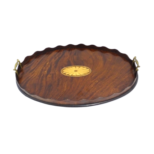 1262 - A Victorian mahogany tray of oval form with scalloped edge gallery, twin brass handles and inlaid sh... 