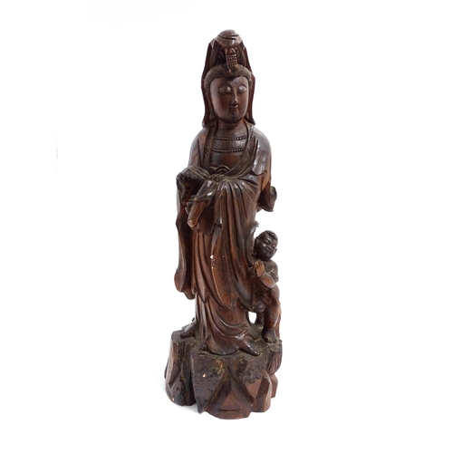 1282 - A Chinese carved hardwood model of Guanyin with a child. Approx. 20