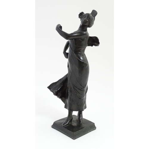 1032 - An Art Nouveau cast bronze figure modelled as a lady dancing with a flower in her hair. Indistinctly... 