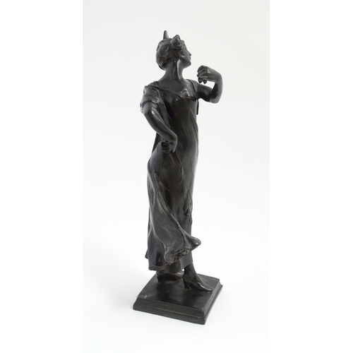 1032 - An Art Nouveau cast bronze figure modelled as a lady dancing with a flower in her hair. Indistinctly... 