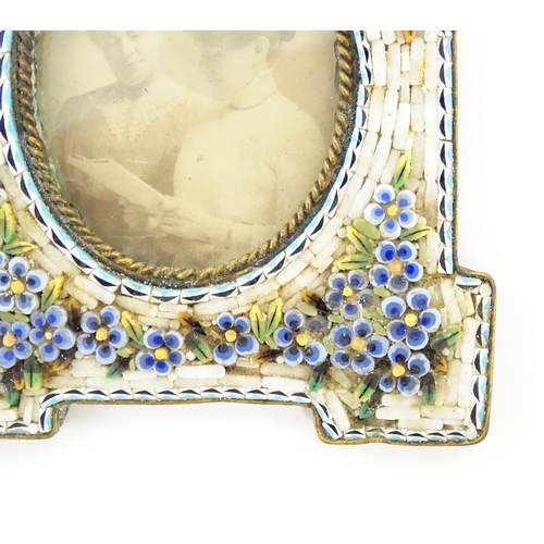 1219 - An early 20thC photograph frame with floral micro mosaic surround. Together with an oval porcelain p... 