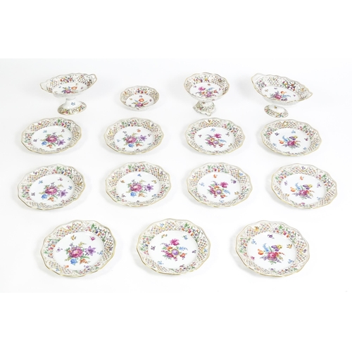 91 - A German part dessert service with pierced borders and floral decoration, to include plates, basket,... 