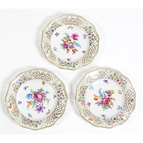 91 - A German part dessert service with pierced borders and floral decoration, to include plates, basket,... 