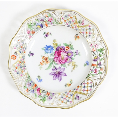 91 - A German part dessert service with pierced borders and floral decoration, to include plates, basket,... 