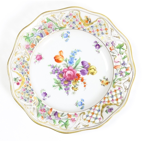 91 - A German part dessert service with pierced borders and floral decoration, to include plates, basket,... 