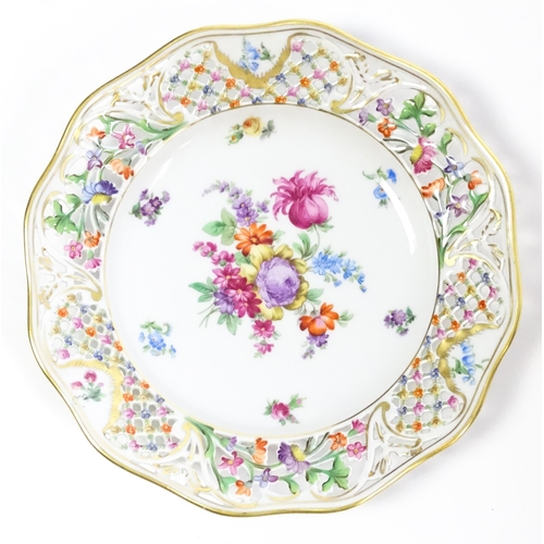 91 - A German part dessert service with pierced borders and floral decoration, to include plates, basket,... 