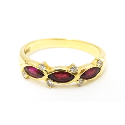 618 - An 18ct gold ring set with three rubies and six diamonds. Ring size approx. P 1/2