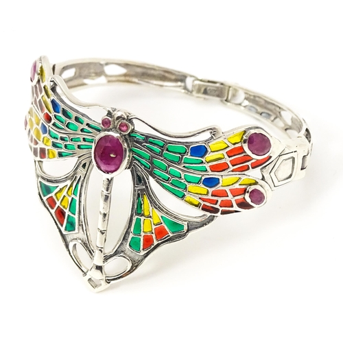 690 - A silver bracelet with dragon fly detail decorated with Plique a jour style detail and red stones.