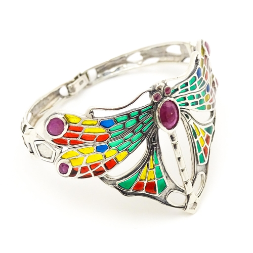 690 - A silver bracelet with dragon fly detail decorated with Plique a jour style detail and red stones.