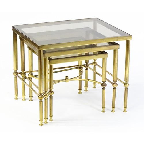 1637 - A nest of three tables with smoked glass tops and raised on reeded tapering legs. 22