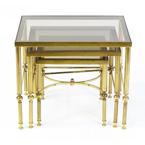 1637 - A nest of three tables with smoked glass tops and raised on reeded tapering legs. 22