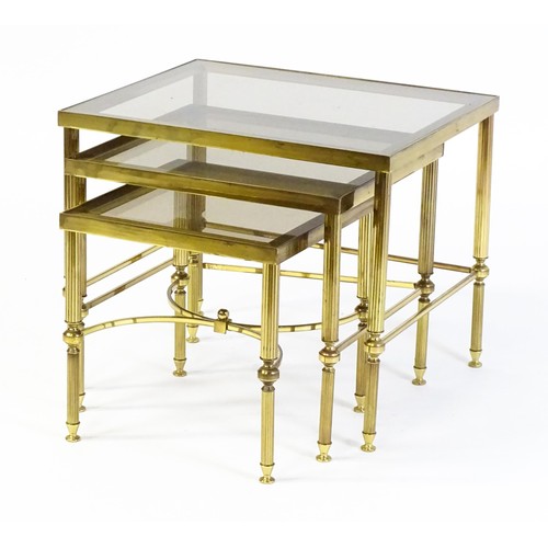 1637 - A nest of three tables with smoked glass tops and raised on reeded tapering legs. 22