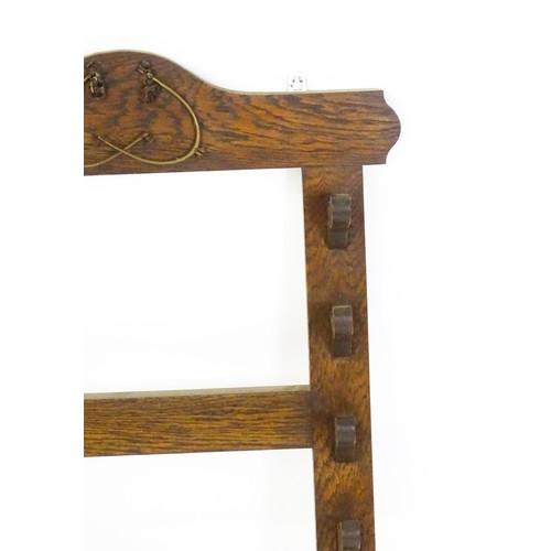 1462 - A 20thC oak whip rack with six shaped hooks. 21