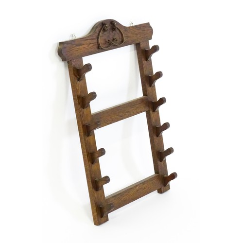 1462 - A 20thC oak whip rack with six shaped hooks. 21