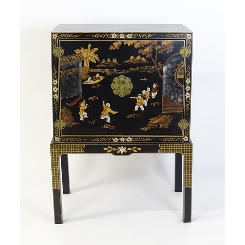 1492 - A modern Oriental cabinet resting on a four legged stand. The painted cabinet depicting, figures, bi... 