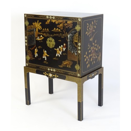 1492 - A modern Oriental cabinet resting on a four legged stand. The painted cabinet depicting, figures, bi... 