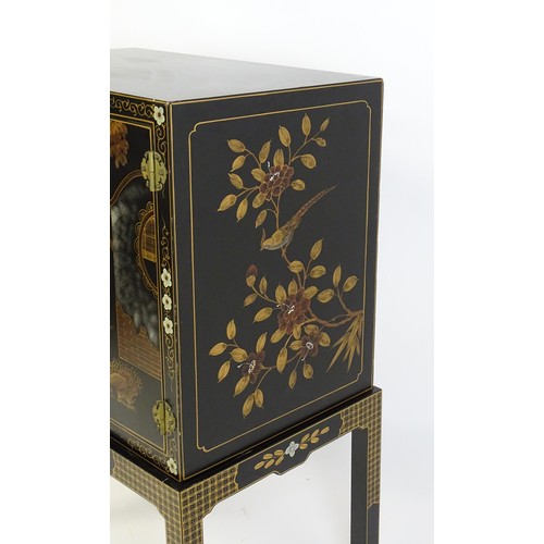 1492 - A modern Oriental cabinet resting on a four legged stand. The painted cabinet depicting, figures, bi... 