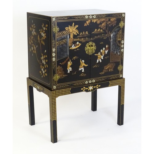 1492 - A modern Oriental cabinet resting on a four legged stand. The painted cabinet depicting, figures, bi... 