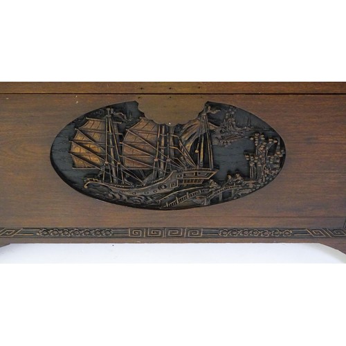 1520 - A 20thC oriental camphor wood trunk, with a carved front and sides, the carving depicting sail ships... 