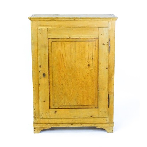 1531 - A 19thC pine cupboard with a moulded top above a single panelled door and raised on four bracket fee... 