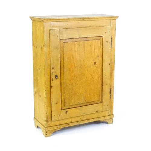 1531 - A 19thC pine cupboard with a moulded top above a single panelled door and raised on four bracket fee... 