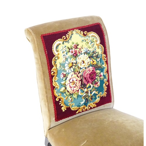 1536 - A late 19thC / early 20thC nursing chair with a needlework backrest, sprung seat and raised on taper... 