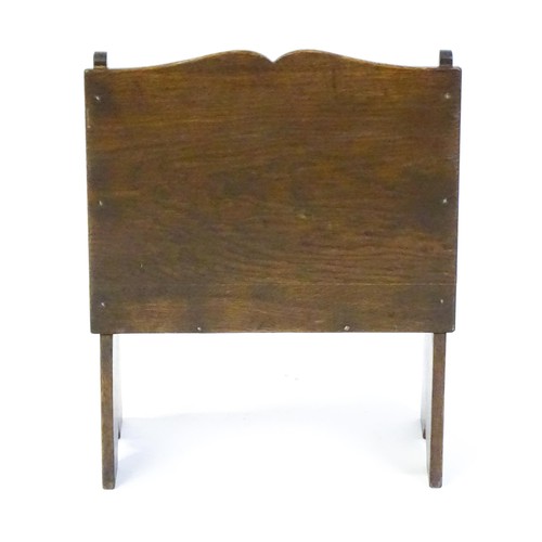 1551 - An early / mid 20thC oak magazine rack with a carved rosette within a carved lozenge to the front. 1... 