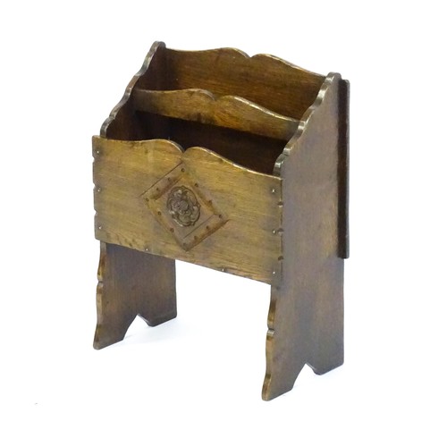 1551 - An early / mid 20thC oak magazine rack with a carved rosette within a carved lozenge to the front. 1... 