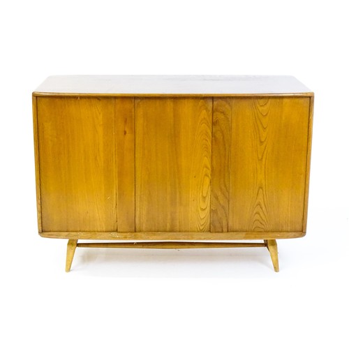 1629 - Vintage / Retro: An Ercol elm sideboard (model 366), the figured elm top above three panelled cupboa... 