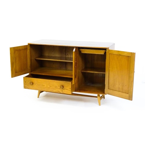 1629 - Vintage / Retro: An Ercol elm sideboard (model 366), the figured elm top above three panelled cupboa... 