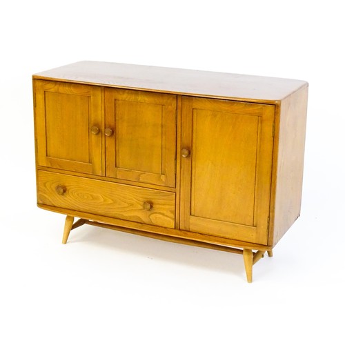 1629 - Vintage / Retro: An Ercol elm sideboard (model 366), the figured elm top above three panelled cupboa... 