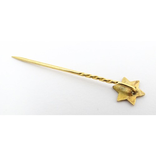 679 - Judaica Interest: A yellow metal stick pin surmounted by Star of David. Approx 1 3/4