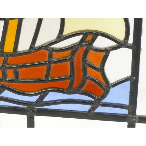 1265 - A 20thC stained glass panel depicting a sailing ship with flag. Approx. 33