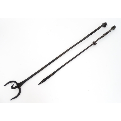 1303A - Two blacksmith made fire tools in the manner of Aaron Petersen with twist handle and rams head finia... 