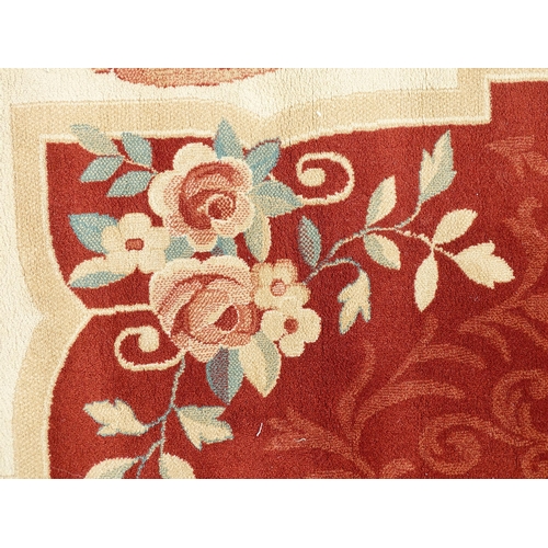 1336 - Carpet / Rug : A red ground rug with central floral vignette and garland with foliate detail with cr... 