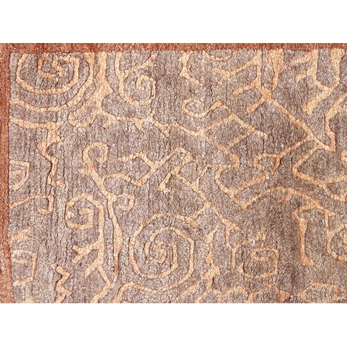 1337 - Carpet / Rug : A Nepalese woollen hand knotted rug worked in terracotta, taupe and beige. Approx. 70... 