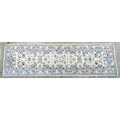 1338 - Carpet / Rug : A beige ground runner with floral and foliate detail worked in shades of blue.  Appro... 