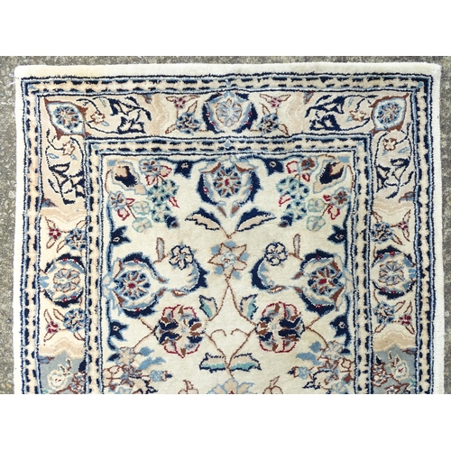 1338 - Carpet / Rug : A beige ground runner with floral and foliate detail worked in shades of blue.  Appro... 