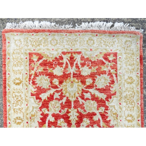 1339 - Carpet / Rug : A salmon red ground Runner  with beige border, decorated with floral and foliate deta... 