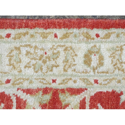 1339 - Carpet / Rug : A salmon red ground Runner  with beige border, decorated with floral and foliate deta... 