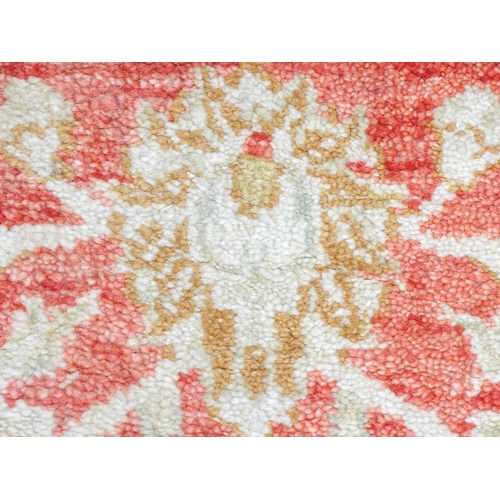 1339 - Carpet / Rug : A salmon red ground Runner  with beige border, decorated with floral and foliate deta... 