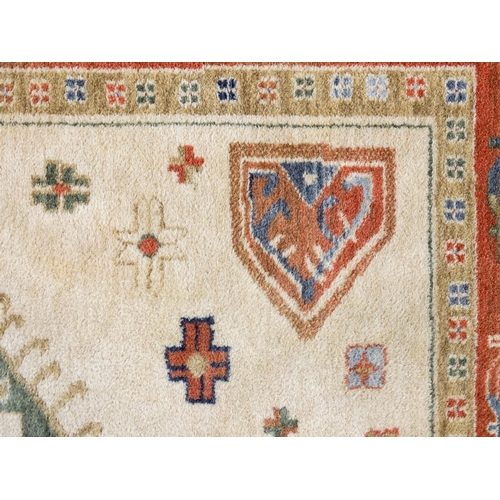 1341 - Carpet / Rug : A cream ground rug with dark salmon / terracotta borders, decorated with geometric an... 