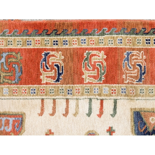 1341 - Carpet / Rug : A cream ground rug with dark salmon / terracotta borders, decorated with geometric an... 