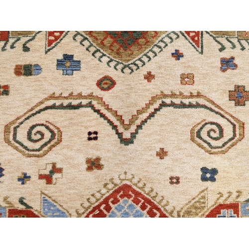 1341 - Carpet / Rug : A cream ground rug with dark salmon / terracotta borders, decorated with geometric an... 