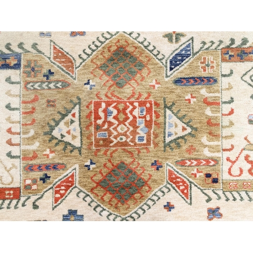 1341 - Carpet / Rug : A cream ground rug with dark salmon / terracotta borders, decorated with geometric an... 