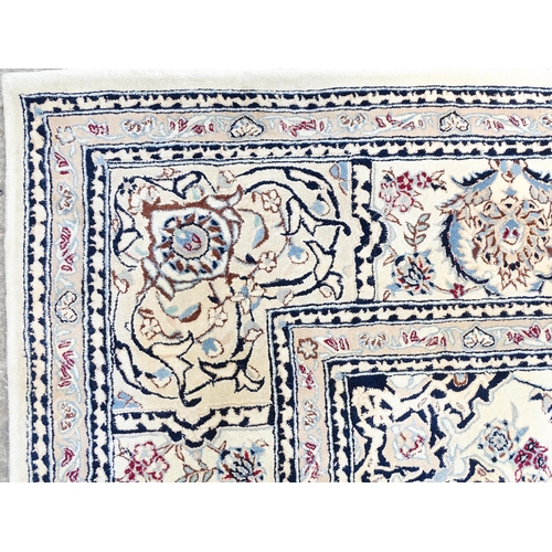 1342 - Carpet / Rug : A beige ground rug with floral and foliate detail worked in shades of blue.  Approx. ... 