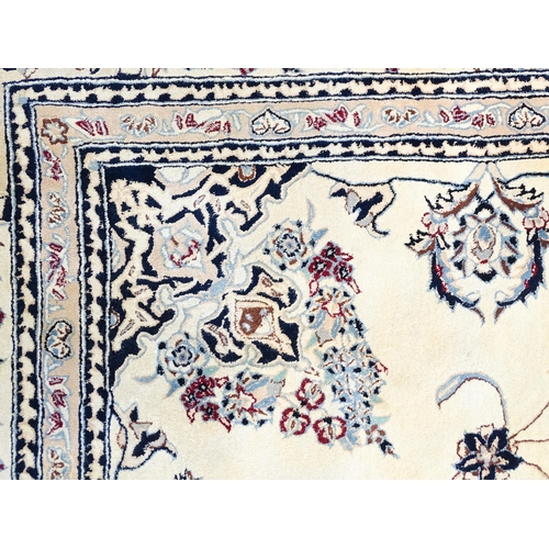 1342 - Carpet / Rug : A beige ground rug with floral and foliate detail worked in shades of blue.  Approx. ... 