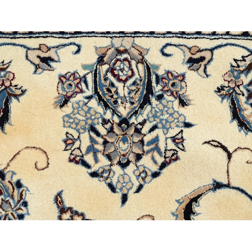 1342 - Carpet / Rug : A beige ground rug with floral and foliate detail worked in shades of blue.  Approx. ... 