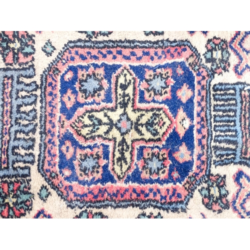 1343 - Carpet / Rug : A salmon pink ground rug with geometric and floral motifs and borders worked in blue ... 